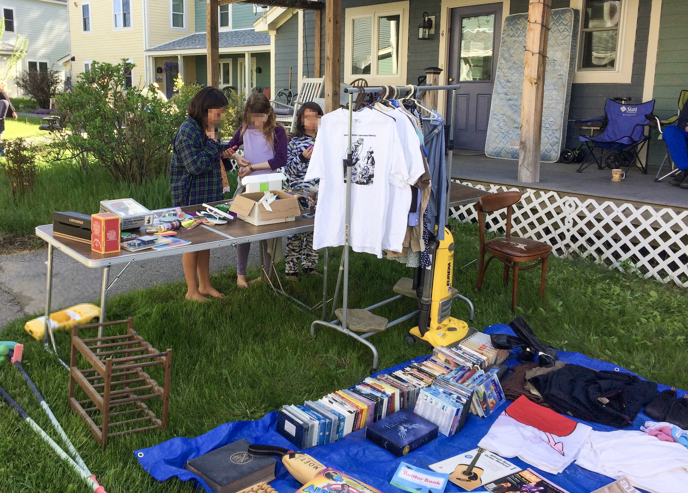 A yard full of giveaway items with children perusing items on a table