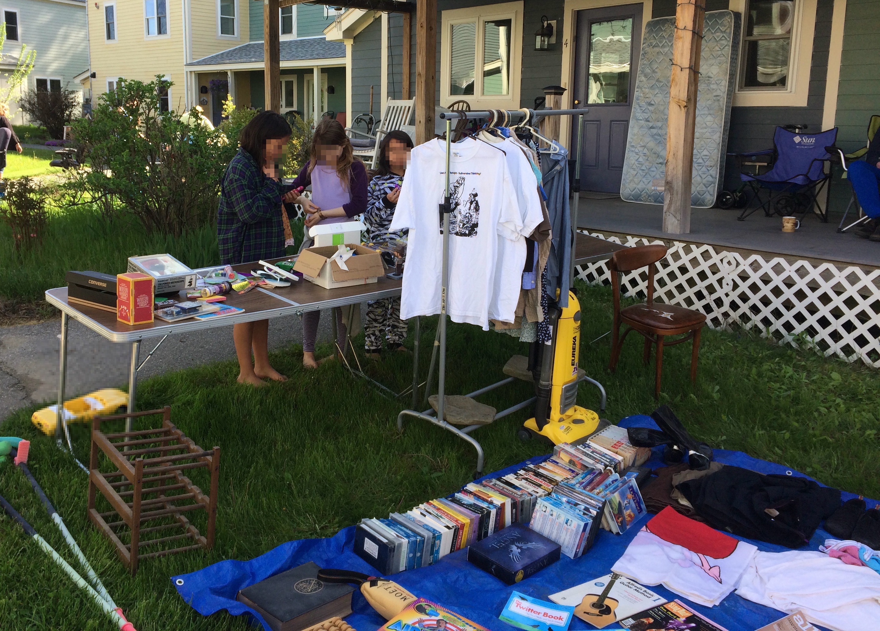 three girls peruse books and clothes for giveaway